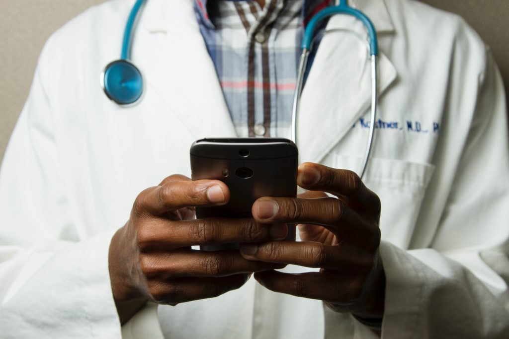 Male doctor using cell phone